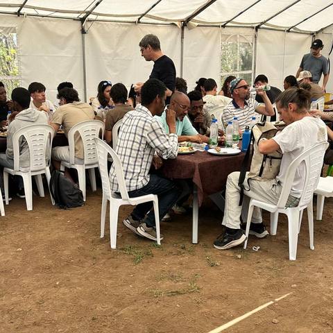 A group sharing lunch under the event tent